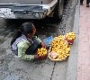 Girl selling potatoes by the sidewalk