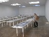 An installation of tables displaying pages from glossy magazines by Fischli and Weiss.