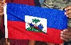 Young hands reach out to embrace the flag of Haiti.