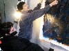 Jane Ellen puts a works from a prior session on the wall. 