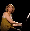She sings and bangs on the piano like some gay Sophie Tucker.