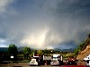 Trucks on a Colorado road, with fast moving storm clouds.