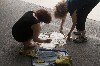 Jane and Nélida placing paper on manhole