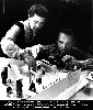 Ray and Charles Eames setting up model for photograph.