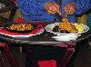 The waiter plating the Paella too far from the table.