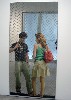 Young people looking through a chain link fence.